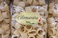 Closeup of bags italian Calamarata ring pasta noodles in shelf of german supermarket