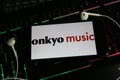 Closeup of smartphone screen with logo lettering online music download service onkyo on computer keyboard