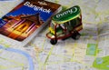 Travel guide, photo book, model of tuk tuk and city map for planning a trip to Bangkok