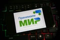 Closeup of mobile phone screen on computer keyboard with logo lettering of MIR MNP russian world payment system