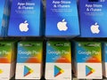 Closeup of Apple app store iTunes and Google Play voucher gift Cards in a row in shelf of german shop