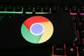 Closeup of mobile phone screen with logo icon of google chrome browser on computer keyboard