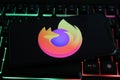 Closeup of mobile phone screen with logo icon of mozilla firefox browser on computer keyboard