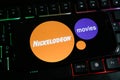 Closeup of mobile phone screen with logo lettering of film production company nickelodeon movies on computer keyboard