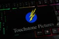 Closeup of mobile phone screen with logo lettering of film production company touchstone pictures on computer keyboard Royalty Free Stock Photo