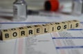 Closeup of word on borreliosis laboratory requisition slip with syringe and vial