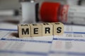 Closeup of word mers on laboratory requisition slip with syringe and vial