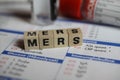 Closeup of word mers on laboratory requisition slip with syringe and vial