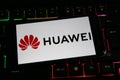 Closeup of mobile phone screen with logo lettering of huawei on computer keyboard Royalty Free Stock Photo