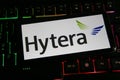 Closeup of mobile phone screen with logo lettering of Hytera communications on computer keyboard