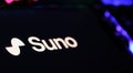 Closeup of Smartphone with logo lettering of AI music generator Suno on computer keyboard Royalty Free Stock Photo