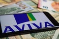 Closeup of smartphone with logo lettering of aviva insurance company on paper money currency