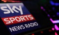 Closeup of smartphone with logo lettering of Sky Sports News Radio on computer keyboard