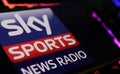 Closeup of smartphone with logo lettering of Sky Sports News Radio on computer keyboard