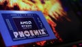 Closeup of smartphone screen with logo lettering of AMD Phoenix APU processor on computer keyboard