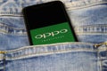 Closeup of smartphone screen with logo lettering of chinese oppo mobile phone company in blue jeans pocket