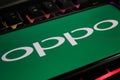 Closeup of smartphone screen with logo lettering of chinese oppo mobile phone company on computer keyboard