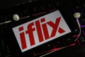 Closeup of smartphone screen with logo lettering of online tv and movie streaming service iflix on illuminated computer keyboard