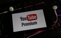 Closeup of smartphone screen with logo lettering of online tv and movie streaming service youtube premium on illuminated computer Royalty Free Stock Photo