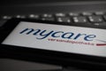 Close up of mobile phone screen on computer keyboard with logo lettering of german online mail-order pharmacy mycare Royalty Free Stock Photo