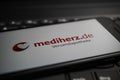 Close up of mobile phone screen on computer keyboard with logo lettering of german online mail-order pharmacy mediherz.de Royalty Free Stock Photo