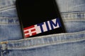 Close up of smartphone screen in blue jeans pocket with logo lettering of italian mobile phone provider TIM telecom italia