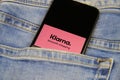 Close up of two isolated mobile phones with payment provider Klarna logo lettering in jeans pocket