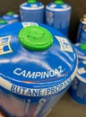 Closeup of blue camping campingaz butane propane gas cylinders in shelf of german supermarket