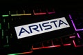 Closeup of mobile phone screen with logo lettering of arista networks on computer keyboard Royalty Free Stock Photo