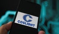 Closeup of phone screen with logo lettering of chinses coslight battery manufacturer, blurred power circuit background