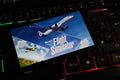 Closeup of smartphone with logo lettering of microsoft flight simulator game on computer keyboard