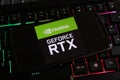 Closeup of smartphone with logo lettering of nvidia geforce rtx cpu on computer keyboard