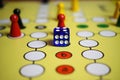 Closeup of yellow game board with colorful pieces and dice of mensch ÃÂ¤rgere dich nicht