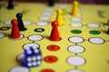 Closeup of yellow game board with colorful pieces and dice of mensch ÃÂ¤rgere dich nicht