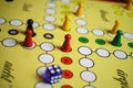 Closeup of yellow game board with colorful pieces and dice of mensch ÃÂ¤rgere dich nicht