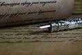 Macro closeup of retro ink pen, old vintage paper with handwritten text Royalty Free Stock Photo