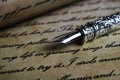 Macro closeup of retro ink pen, old vintage paper with handwritten text Royalty Free Stock Photo