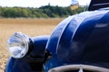 Close up of isolated silver headlight of black French classic cult car 2CV in rural area