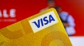 Closeup of on single isolated golden visa credit card, blurred online shop background