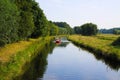 View on rural river Niers in late summer with people paddle in dinghies for fun