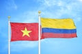 Vietnam and Colombia two flags on flagpoles and blue sky