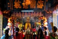 HO CHI MINH CITY, VIETNAM - JANUARY 5. 2015: View on buddhist believers inside chinese temple praying at colorful altar