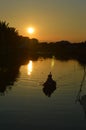 Small rowing fishing boat in silhouette at sunset Hoi An VIetnam 