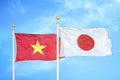 Vietnam and Japan two flags on flagpoles and blue sky