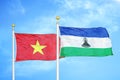 Vietnam and Lesotho two flags on flagpoles and blue sky