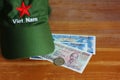 Dong Vietnam money with Vietnam hat on wood table Royalty Free Stock Photo