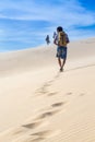 2015-01-03 Vietnam, region Mui Ne. People walk along the sand dunes, view from the back, footprints on the sand