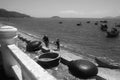 Vietnam. Round braided fishermen`s boats are on the shore. Small wooden fishing boats are in the sea. Black and white