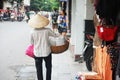 Vietnam woman vendors bearing hawker basket walking on street road for sale local food product to vietnamese people and foreign Royalty Free Stock Photo