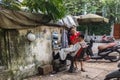 Vietnamese barber cuts a client in street barbershop